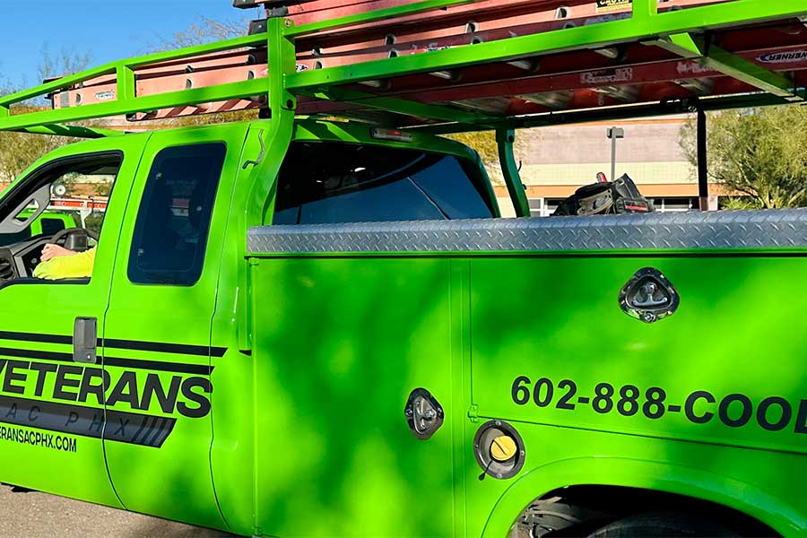 Bright green HVAC service truck with ladder rack