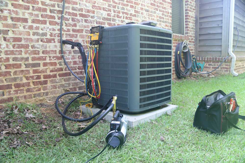 HVAC system undergoing maintenance with vacuum pump and tools