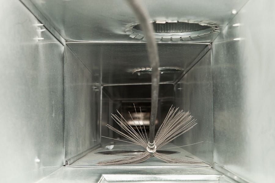 Inside view of an air duct being cleaned with a rotary brush