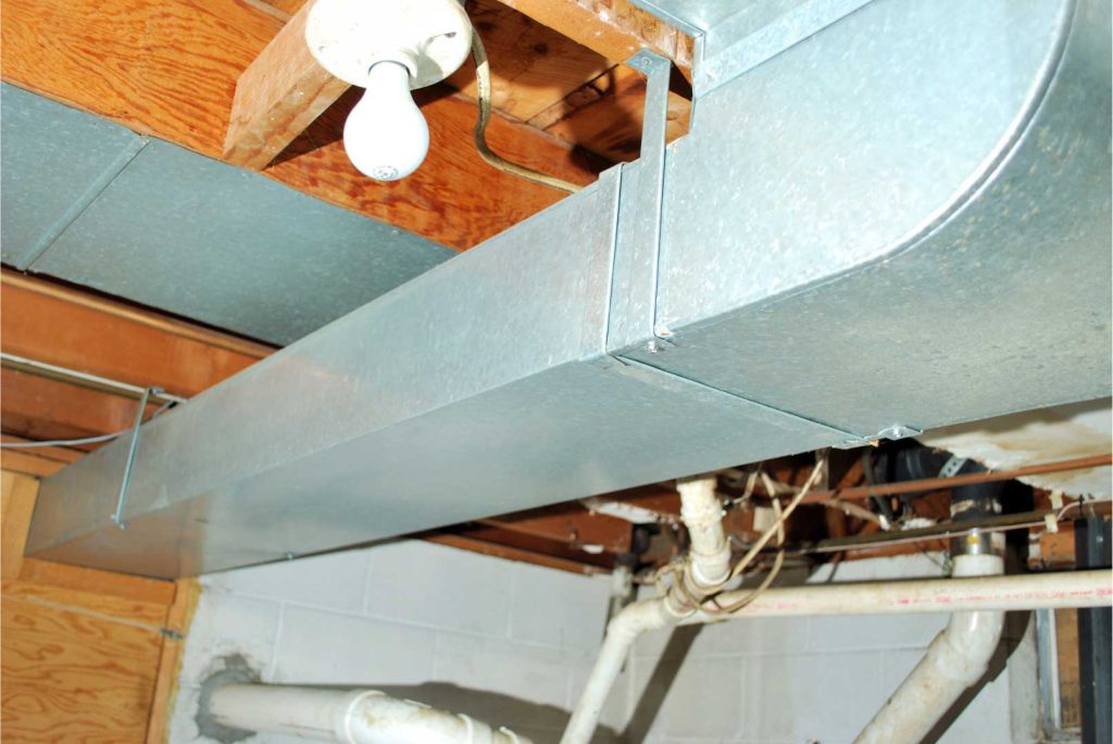 Exposed metal HVAC ductwork installed in a basement ceiling