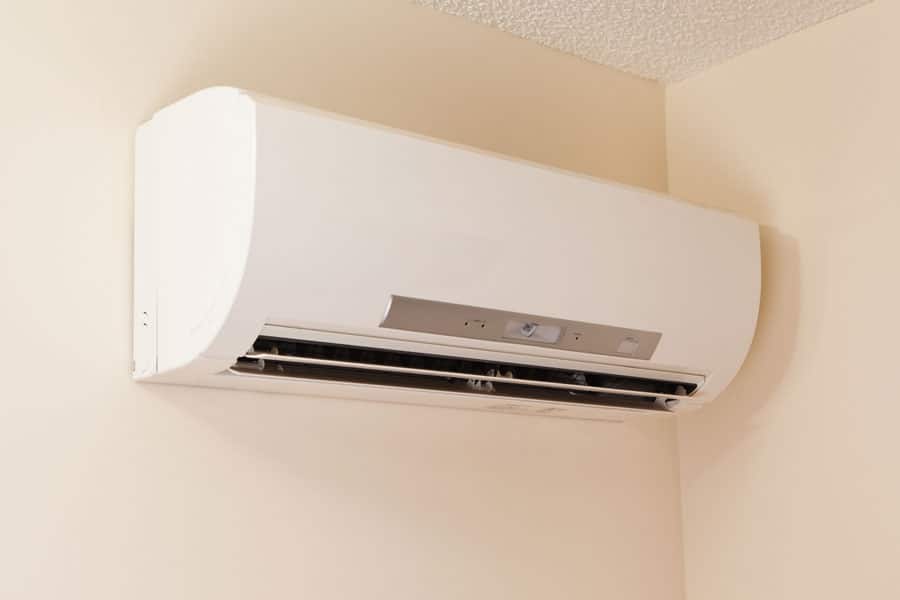 Wall-mounted ductless mini-split air conditioner in a corner room