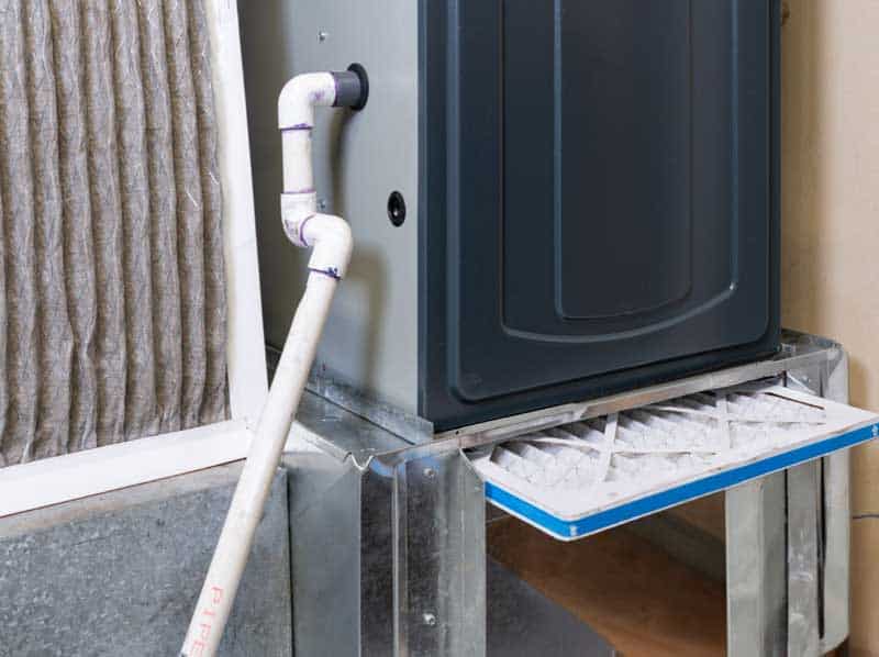 Furnace unit showing drain pipe and open filter tray