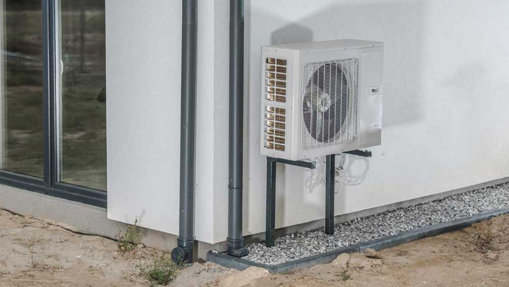 Wall-mounted mini-split AC condenser installed on the exterior of a modern home