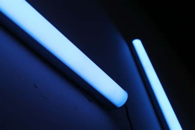 Close-up of glowing UV light tubes mounted on a wall